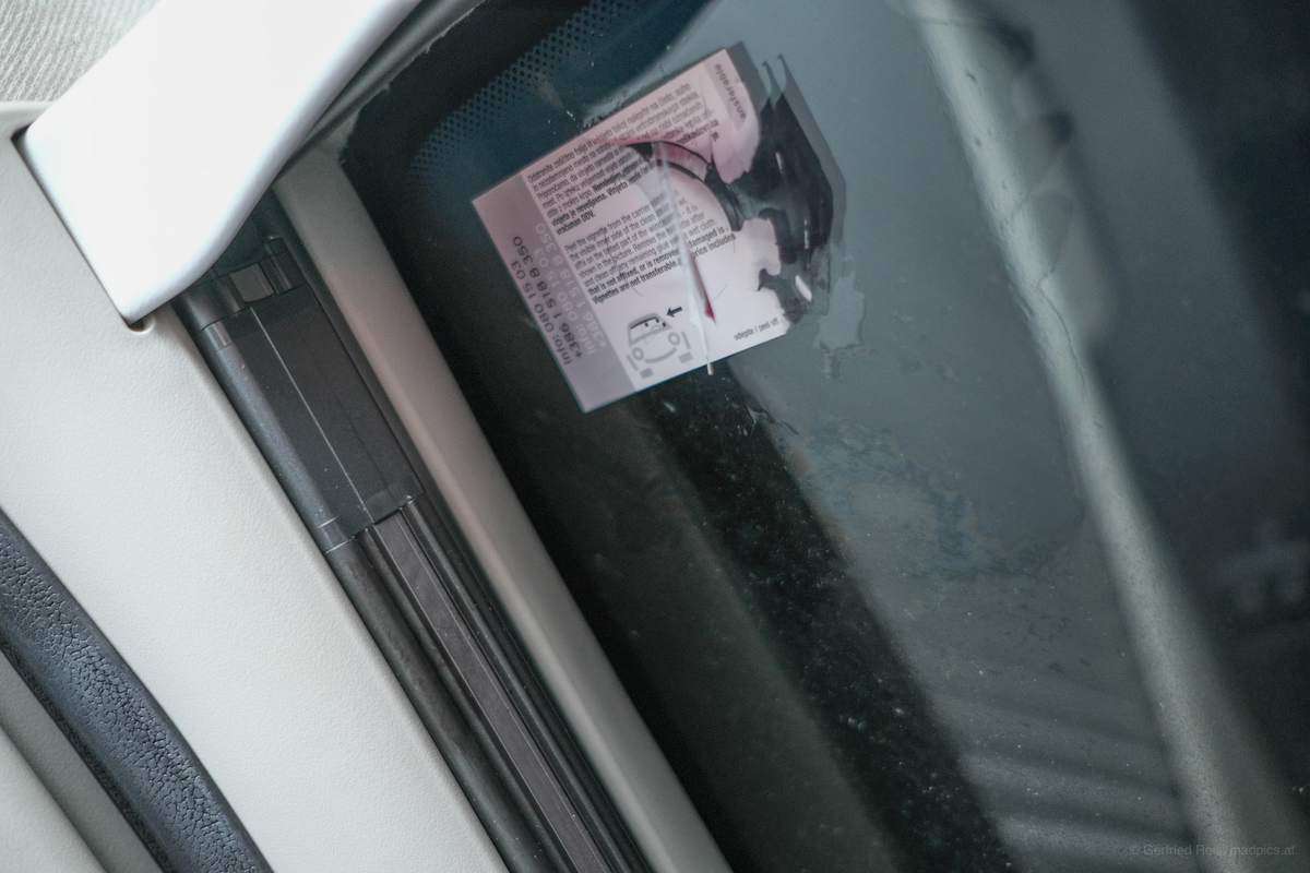 Halb abgelöste Vignette an Scheibe