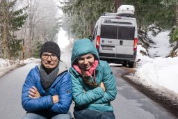 Wohnmobil im Schnee mit dick angezogenen Personen