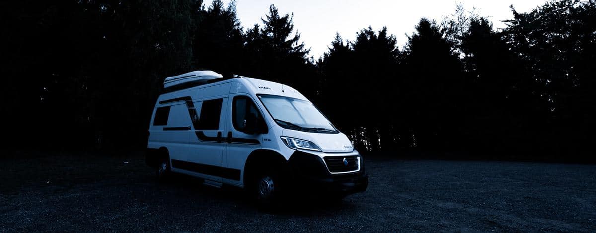 Ein Wohnmobil steht vor einem Wald